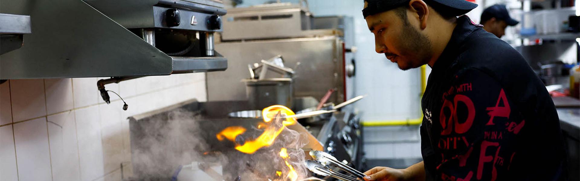 Chef Khimraj Nepali prepares a dish using the recipe from Aiman, the AI Chef