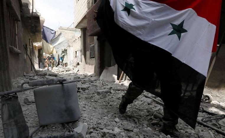 جندي سوري يرفع علم البلاد