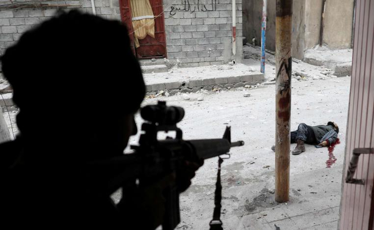 جندي عراقي بالقرب من جثة لمقاتل من داعش