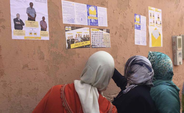 مغربيات يقرأن ملصقات انتخابية