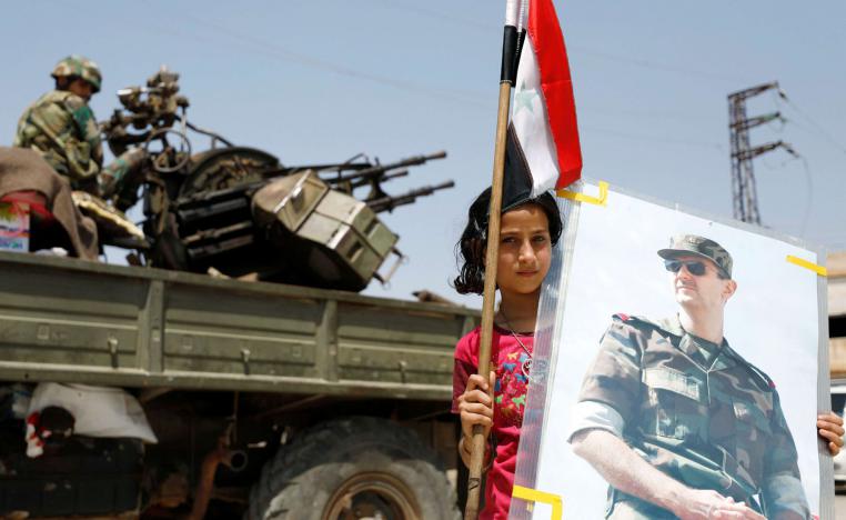 طفلة سورية ترفع صورة للأسد على خلفية مدفع مقاوم للطائرات