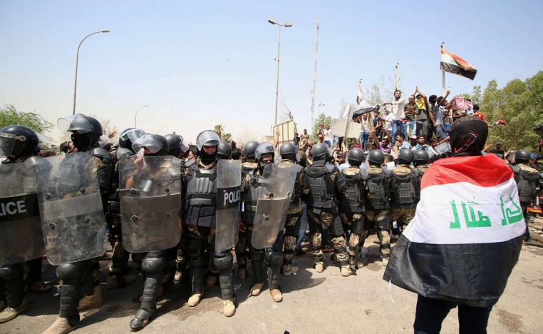متظاهر عراقي أمام قوات مكافحة الشغب