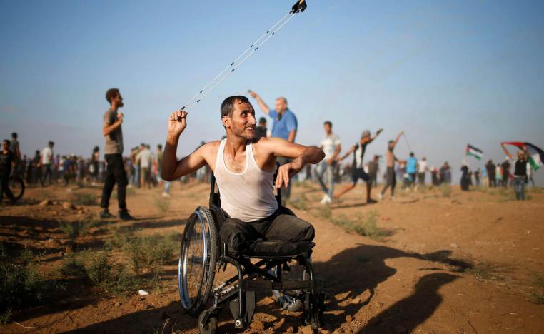 معوق فلسطيني يلقي بالحجارة على جنود إسرائيليين على حدود غزة