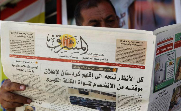 عراقي يتصفح صحيفة محلية