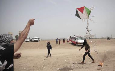 طفل فلسطيني يطير طائرة ورقية تحمل مادة حارقة على الحدود بين غزة واسرائيل