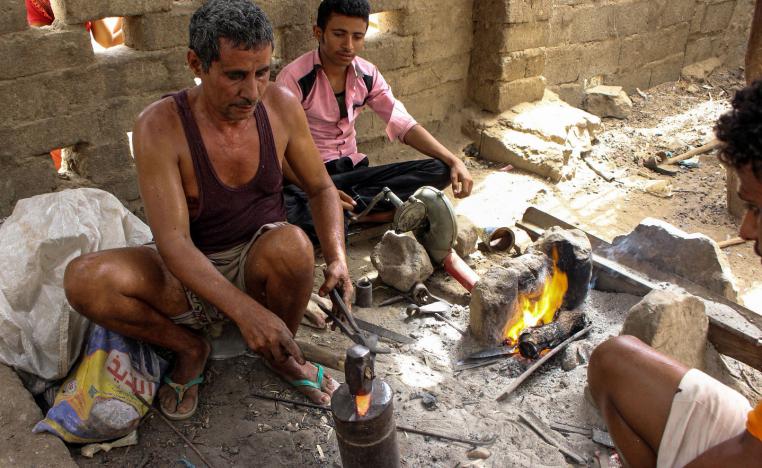 Yemenis burn wood to create a fire to reform metal salvaged from fallen rockets in air strikes to create blades for new daggers, in the northern district of Yemen's Hajjah province on July 28, 2018.