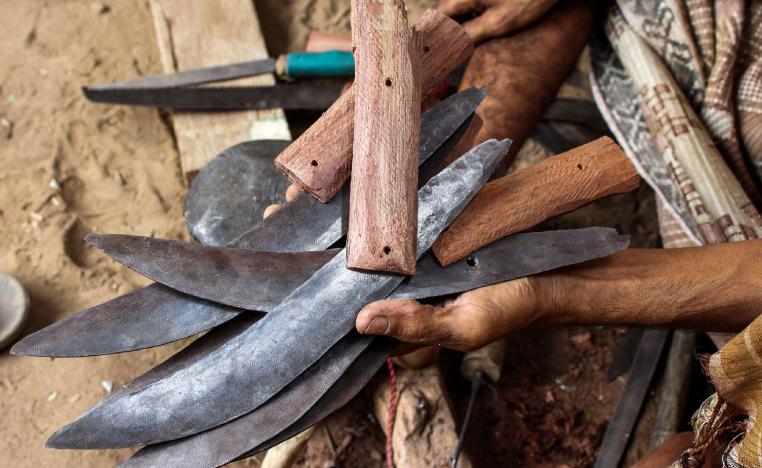 A Yemeni man holds newly-formed blades and handles of daggers created by recycling scrap metal of fallen rockets from air strikes, in the northern district of Yemen's Hajjah province on July 28, 2018.