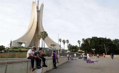 شباب جزائريون يجلسون بالقرب من نصب الشهداء في العاصمة الجزائر