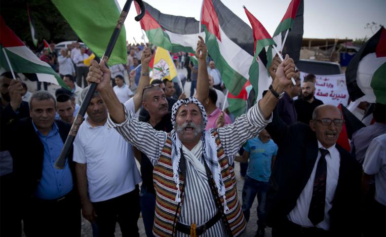 Palestinians protesters fly national flags and chant anti Israel slogans in the West Bank hamlet of Khan al-Ahmar 