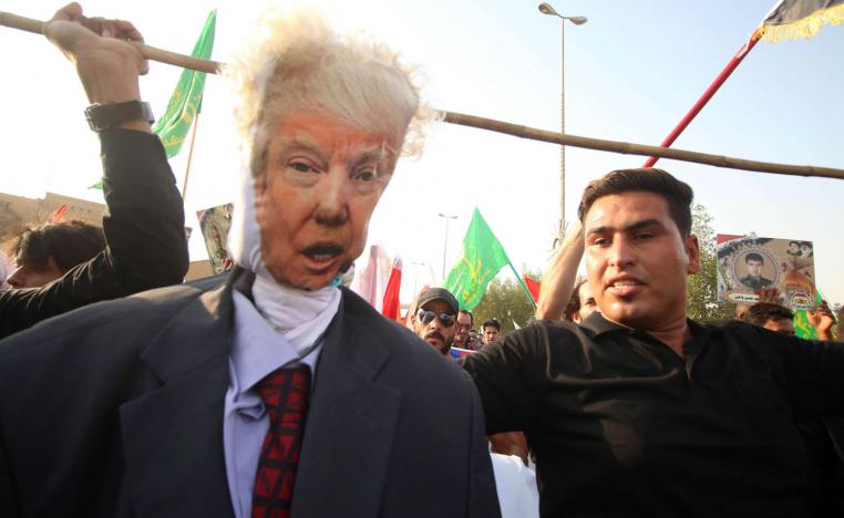 متظاهر يلوح بدمية على شكل الرئيس الأميركي ترامب