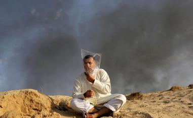 فلسطيني في بيت لاهيا يضع كيسا بلاستيكيا على رأسه في مواجهة الدخان والغازات المسيلة للدموع