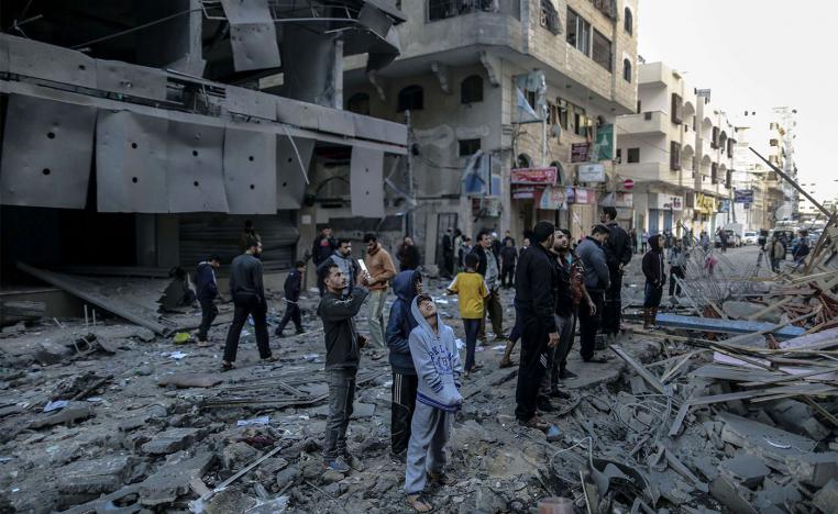 Palestinians inspect the damage of a destroyed residential building in Gaza after hitting by Israeli air strikes 