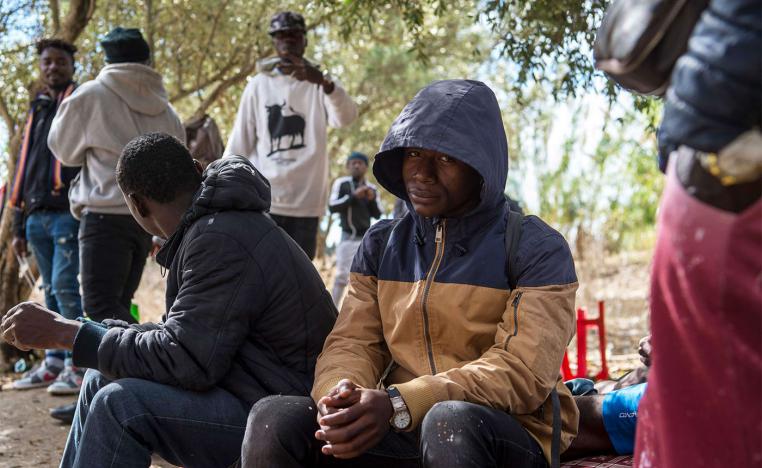 Migrants from Sub-Saharan Africa take shelter while hiding from the police in a forest in the district of Boukhalef of Tangiers