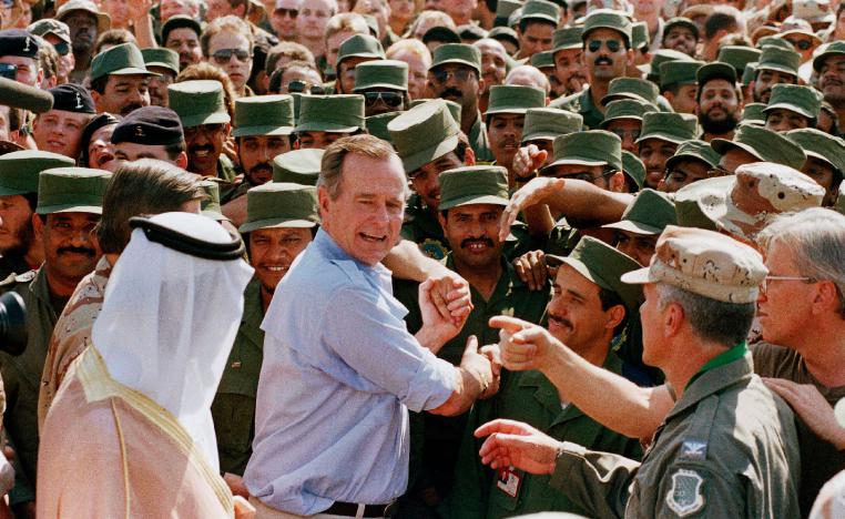 A file photo shows former US President George H.W. Bush being greeted by Saudi troops and others as he arrives in Dhahran, Saudi Arabia, in 1990.