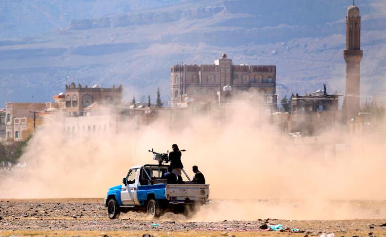Yemeni men stand at the back of an armed pick up as people in the capital Sanaa to show their support to the Shiite Huthi movement against the Saudi-led intervention, on December 19, 2018.