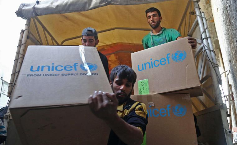 Syrians unload aid packages at al-Nashabia in the rebel-held Eastern Ghouta region