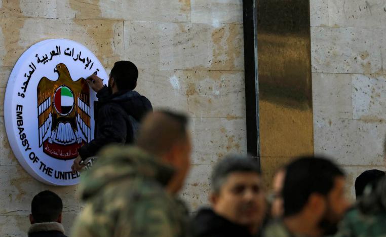 فني يركب شعار سفارة الامارات على واجهة السفارة في دمشق