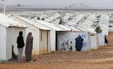 Syrian refugee women stand in front of their homes at Azraq refugee camp, near Al Azraq city, Jordan