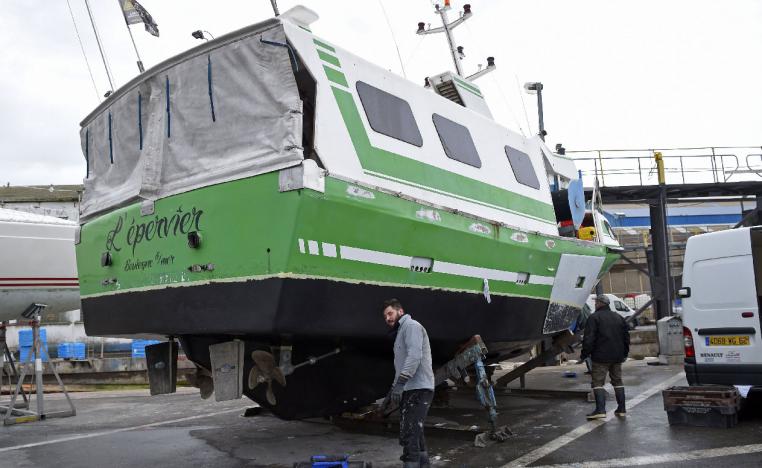 French workers repair "L'Epervier" on November 29, 2018, a boat that was stolen and damaged by migrants who tried to cross the English Channel, in Wissant, northern France.