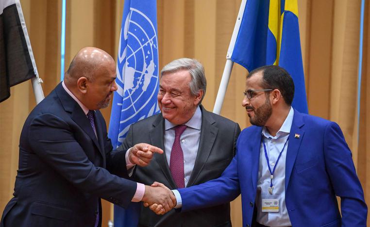 Yemen's FM Khaled al-Yamani (L) and rebel negotiator Mohammed Abdelsalam (R) shake hands
