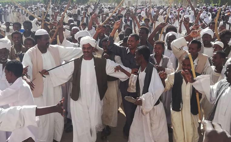 Crowds of supporters of the Sudanese President wave sticks as they gather in Sudan's eastern city of Kassala on January 7, 2019.