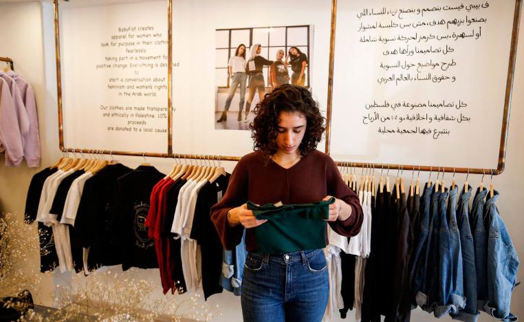 Palestinian fashion designer Yasmeen Mjalli speaks while standing in her clothing shop where her label collection "BabyFist" carrying anti-sexual harassment slogans is showcased, in Ramallah in the Israeli-occupied West Bank on December 19, 2018.