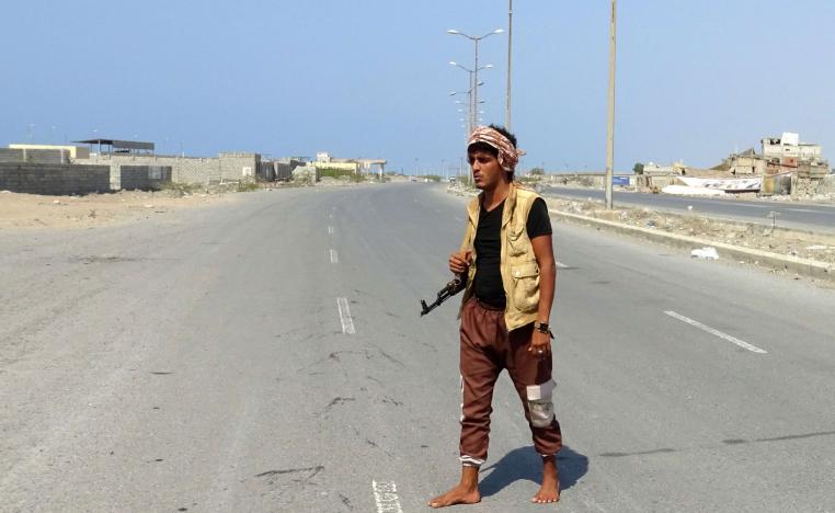 A member of the Yemeni pro-government forces walks with his rifle at the eastern entrance of the port city of Hodeidah on December 30, 2018
