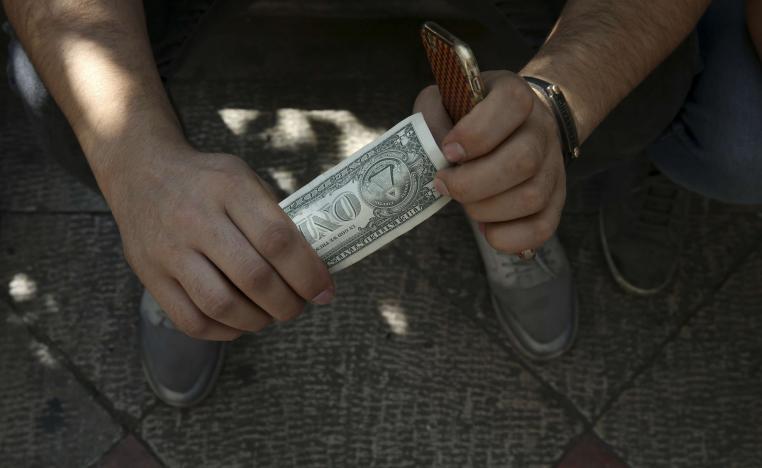 An Iranian street money exchanger holds a U.S. banknote in downtown Tehran, Iran, Tuesday, Oct. 2, 2018.
