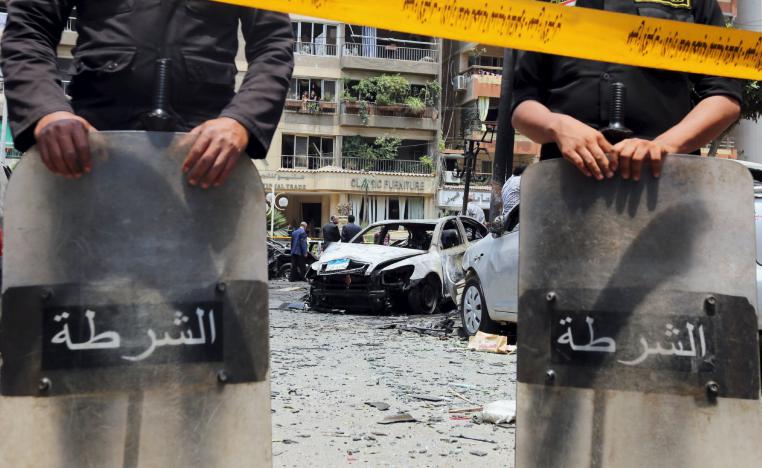 Policemen investigate the site of a car bomb attack on the convoy of Egyptian public prosecutor Hisham Barakat near his house at Heliopolis district in Cairo, Egypt, June 29, 2015.
