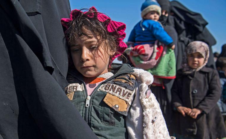 Women and children stand in a field after they fled from the Baghouz area in the eastern Syrian province of Deir Ezzor on February 12, 2019 during an operation by the US-backed Syrian Democratic Forces (SDF) to expel hundreds of Islamic State group (IS) jihadists from the region.