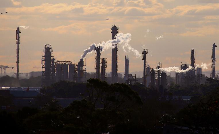 طيور وطائرة تحلق فوق الانبعاثات من مداخن مصنع كيماوي في سيدني بأستراليا 