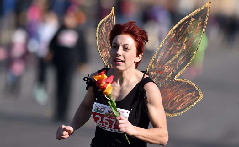 امرأة تضع جناحين وتركض في مسيرة بمناسبة يوم المرأة العالمي في العاصمة البيلاروسية مينسك