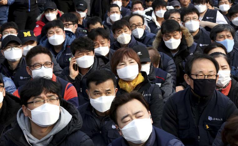 موظفون في كوريا الجنوبية يضعون كمامات لاتقاء الهواث الملوث