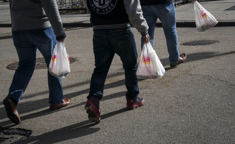 أشخاص يحملون أكياسا بلاستيكية تستعمل مرة واحدة