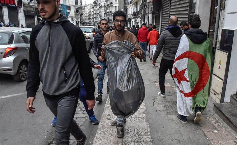 شباب متطوعون يرفعون القمامة المتخلفة بعد الاحتجاجات في الشوارع في الجزائر