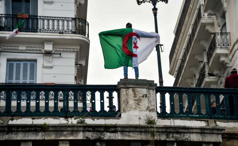 شاب جزائري يرفع علم بلاده على جسر في العاصمة