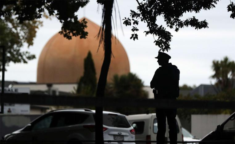 An armed policeman stands guard in front of the Masjid Al Noor Mosque in Christchurch