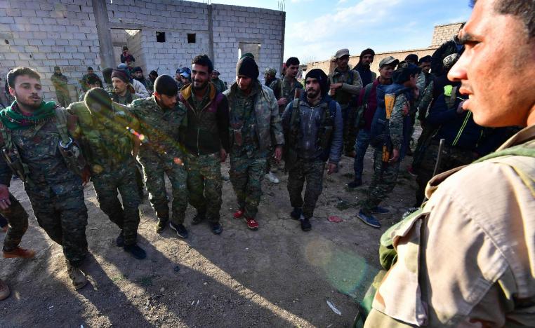 Fighters from the Syrian Democratic Forces (SDF) celebrate as they come back from the frontline in the Islamic State group's last remaining position in the village of Baghouz in the countryside of the eastern Syrian province of Deir Ezzor on March 19, 2019.