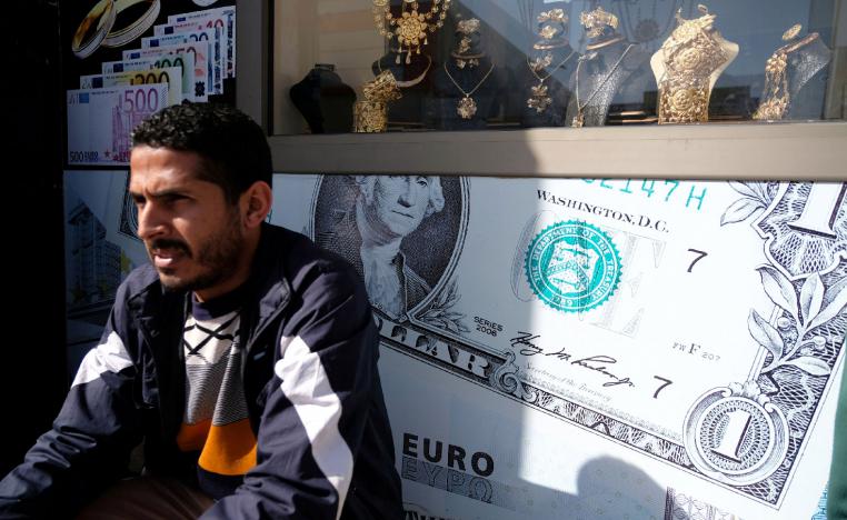 A man sits next to a gold shop and a currency exchange in Benghazi, Libya February 4, 2019.