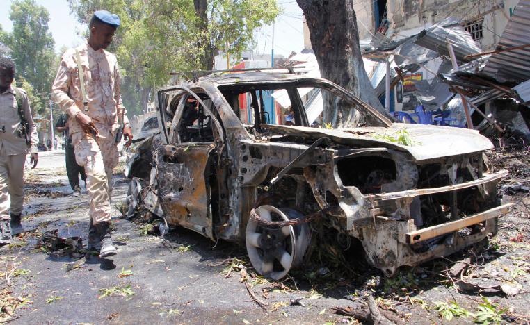 A Somali soldier walks near the wreckage of a car in Mogadishu, Somalia, Thursday March 7, 2019.