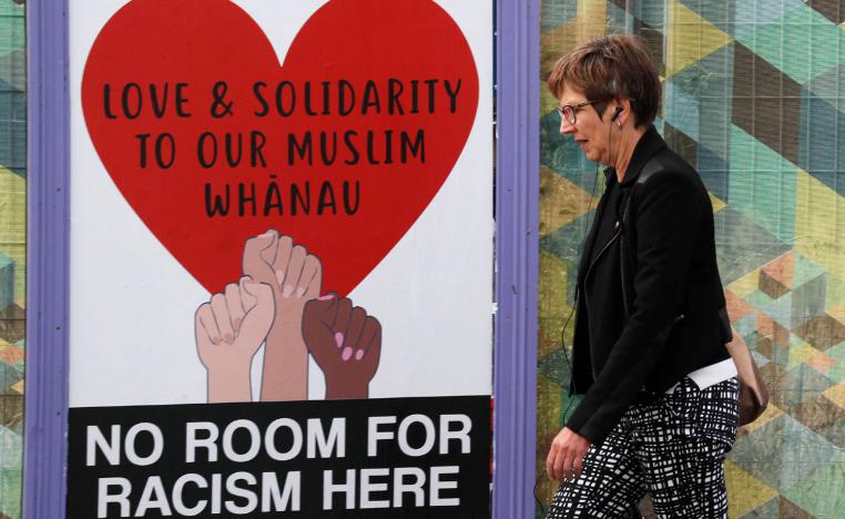 نيوزلندية تمر بلافتة ضد العنصرية