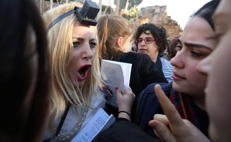 A member of the liberal Jewish religious movement "Women of the Wall" argues with Ultra Orthodox Jewish girls.