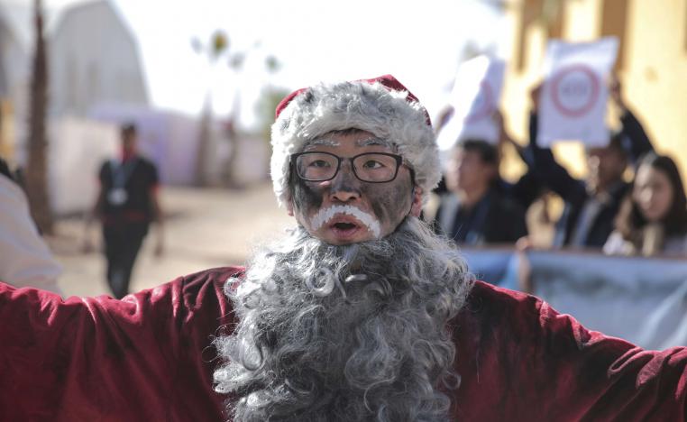 ناشط يضع لحية مستعارة تشير إلى تلوث الهواء في مسيرة بمراكش للتوعية بآثار التغير المناخي