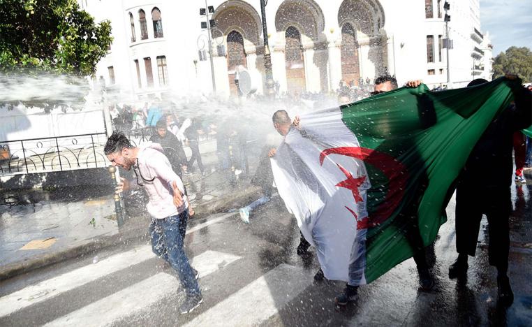 Riot police spray protesters with water during a protest in Algiers against Bensalah's appointment