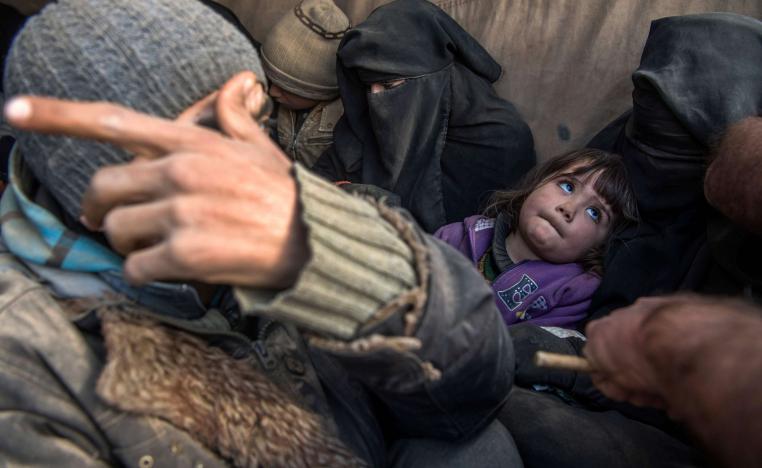 Women and children displaced from Deir Ezzor sit in the back of a truck after they fled the Islamic State (IS) holdout near Baghuz, eastern Syria, on February 11, 2019.