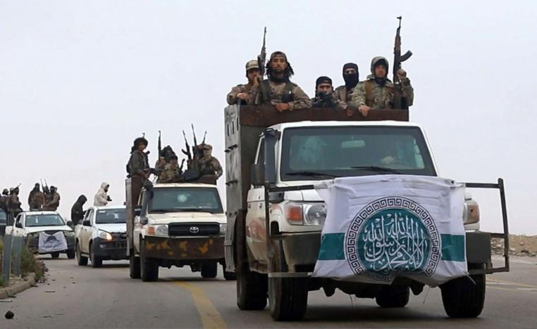 HTS fighters driving their vehicles during a military drill in northern Syria