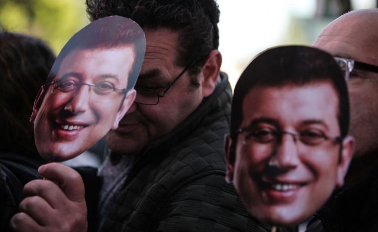 People wear the masks of Ekrem Imamoglu, the main opposition mayoral candidate for Istanbul