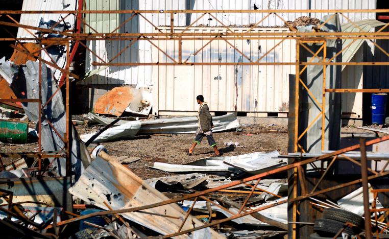 A man walks amidst the debris following a reported air strike on a plastic factory in Sanaa's Jeraf district on April 10, 2019.