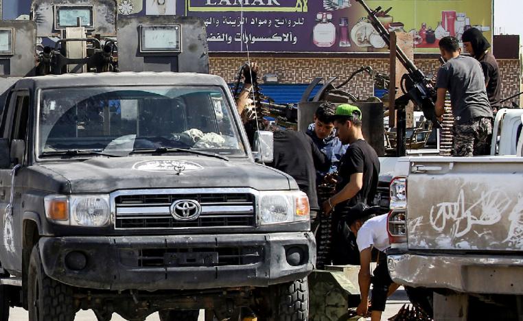 This picture taken on April 10, 2019 from the side of forces loyal to Libya's Government of National Accord (GNA) shows a view of fighters gearing up by technicals (improvised pickup trucks mounted with turrets) at the frontline during clashes with forces loyal to strongman Khalifa Haftar south of the capital Tripoli's suburb of Ain Zara.