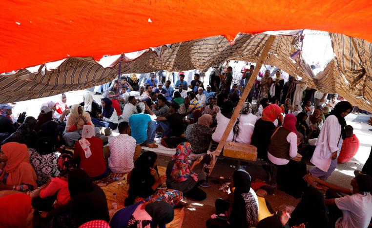 Sudanese protesters gather under a tent outside the defense ministry compound in Khartoum